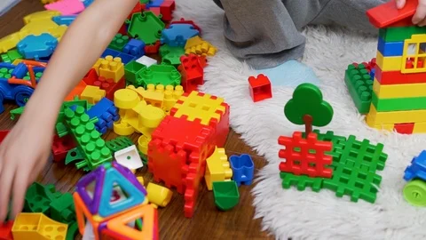 Happy child playing with colored constructor blocks on white Mat. The kid choose Video stock 118648307