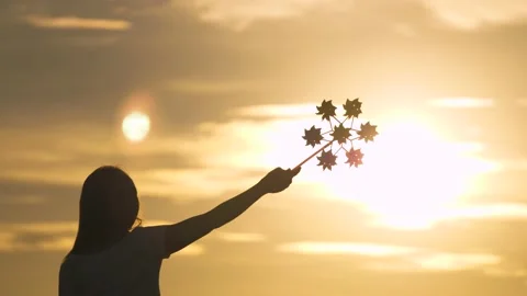 Happy child playing having fun pinwheel. Girl silhouette playing pinwheel park Video stock 148399865