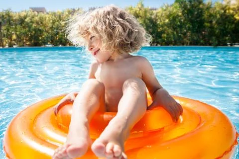 Happy child playing in swimming pool Stock Photos