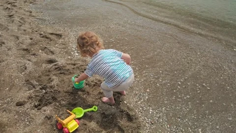 Happy Child Plays with Sand on Beach, Mother Captures Memories with Smartphone Stock Footage 333205262