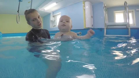 Happy. the child in the pool with the coach.  Stock Footage 82558313