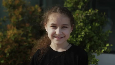 Happy Child in rays of the sun. Little girl face in park close-up portrait Stock Footage 234053960