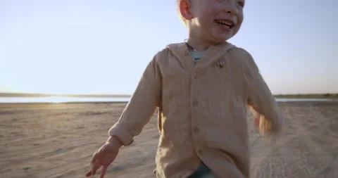 A happy child runs in the sun. Joyful little boy runs in nature. Stock Footage