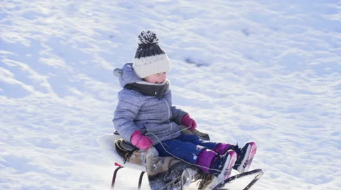 Happy child on sleigh going down the hill slow motion Stock Footage 59796243