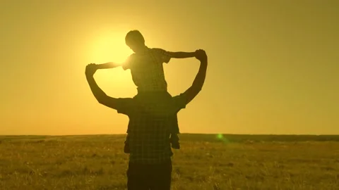 Happy child son sits on his father's neck, plays pilot, flies like super hero Video stock 156021853