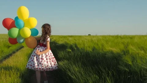 A happy child is spinning with balloons. Stock Footage