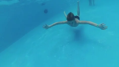 Happy child swims with enjoyment under the water in the pool Stock Footage