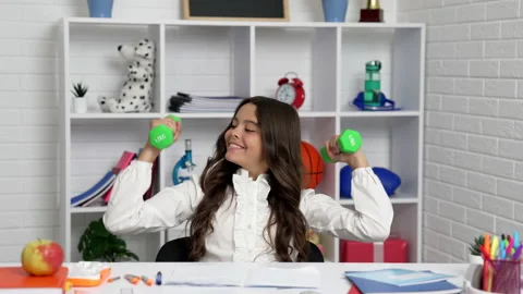Happy child using barbells at school in classroom, sport Stock Footage 219857741