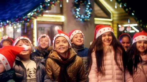 Happy children are jumping , laughing  and looking camera at Christmas night . Stock Footage 120573353