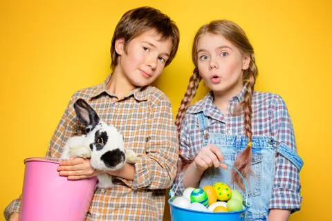 Happy children are posing with Easter attributes on blue  background. Happy c Stock Photos