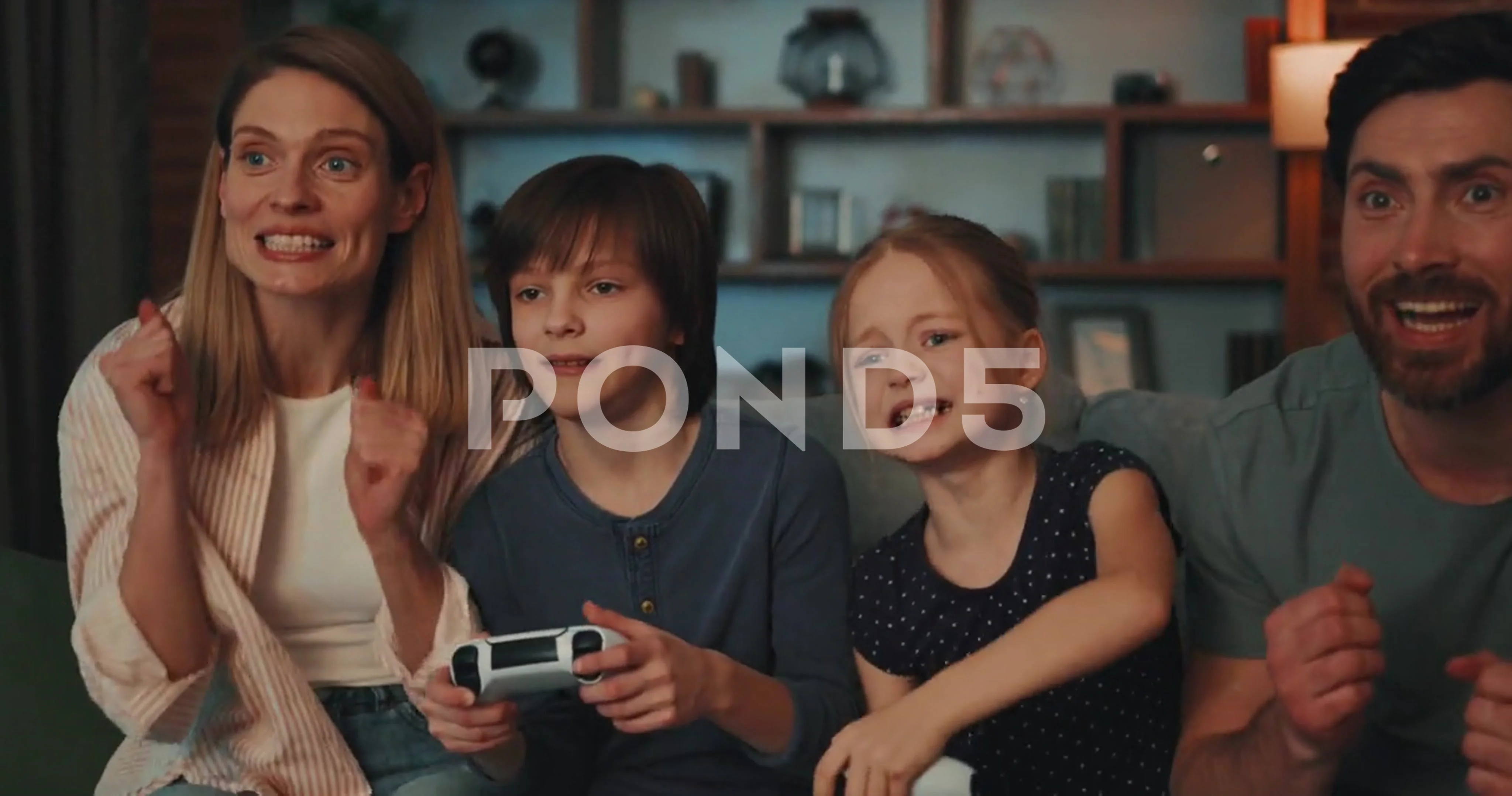 Happy children girl and boy playing video games with parents using Joystick