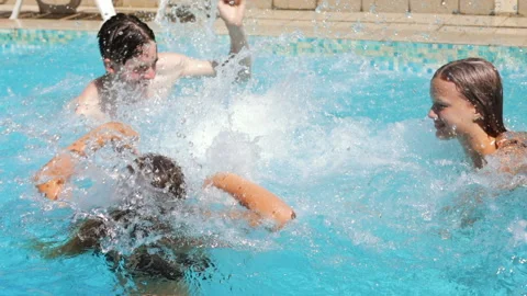 Happy children having fun in a pool splashing water Stock Footage 176899997
