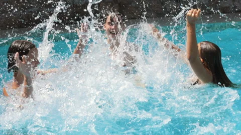 Happy children having fun in a pool splashing water slowmo Video stock 178075830
