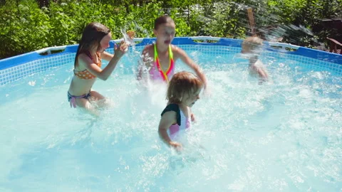 Happy children having fun in a pool splashing water Video stock 245821468
