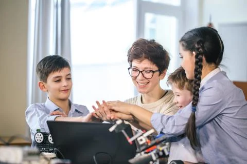 Happy children learn programming using laptops on extracurricular classes Foto stock