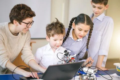 Happy children learn programming using laptops on extracurricular classes Stock Photos