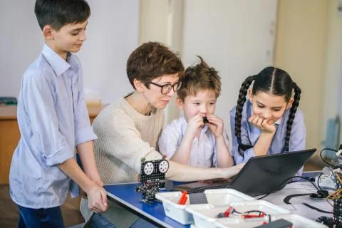 Happy children learn programming using laptops on extracurricular classes Stock Photos