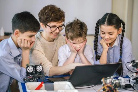 Happy children learn programming using laptops on extracurricular classes Foto stock