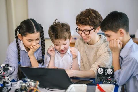 Happy children learn programming using laptops on extracurricular classes Foto stock