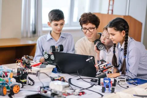 Happy children learn programming using laptops on extracurricular classes 库存照片