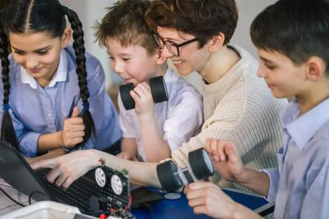 Happy children learn programming using laptops on extracurricular classes 写真素材