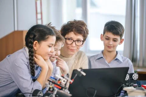 Happy children learn programming using laptops on extracurricular classes Stock Photos