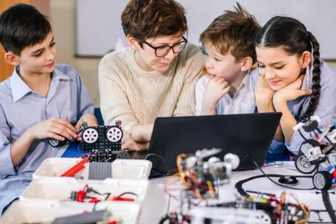 Happy children learn programming using laptops on extracurricular classes 库存照片