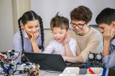 Happy children learn programming using laptops on extracurricular classes Stock Photos