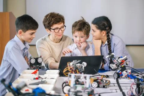Happy children learn programming using laptops on extracurricular classes Stock Photos
