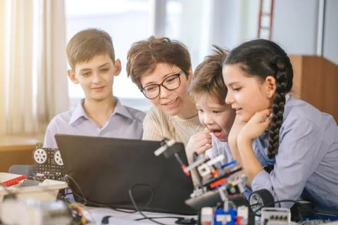Happy children learn programming using laptops on extracurricular classes Foto stock
