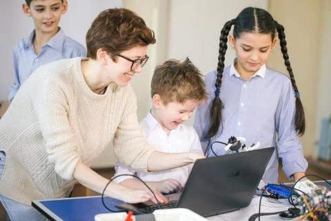 Happy children learn programming using laptops on extracurricular classes 库存照片