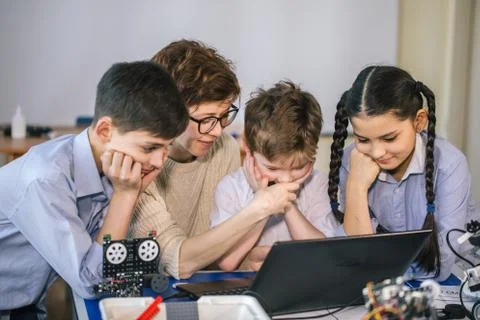Happy children learn programming using laptops on extracurricular classes Foto stock