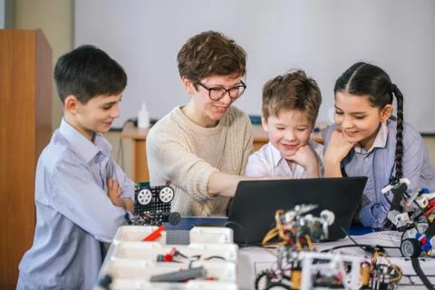 Happy children learn programming using laptops on extracurricular classes 库存照片