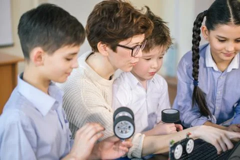 Happy children learn programming using laptops on extracurricular classes 库存照片