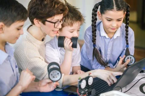 Happy children learn programming using laptops on extracurricular classes Stock Photos
