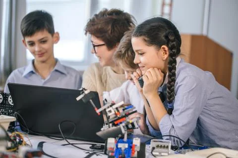 Happy children learn programming using laptops on extracurricular classes 库存照片