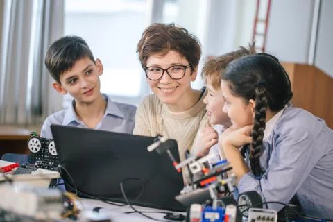 Happy children learn programming using laptops on extracurricular classes Stock Photos