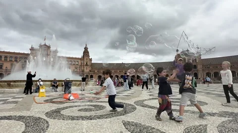 Happy children playing and running after big soap bubbles Stock Footage 337070934