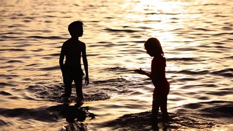 Happy children playing on the beach at the sunset time. Concept of happy Stock Footage 109020942