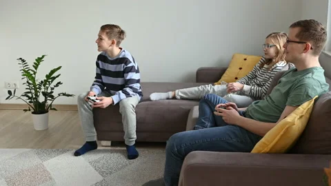 Happy children playing computer games and having fun with father sitting on c Video stock 168461664