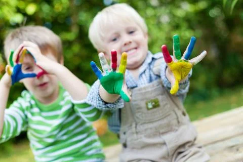 Happy children playing with finger paint Stock Photos