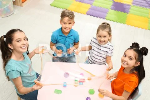 Happy children playing with slime at table indoors, above view Stock ...