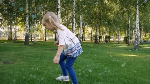 Happy children playing with soap bubbles on a summer nature. Bubbles in the Video stock 99232309