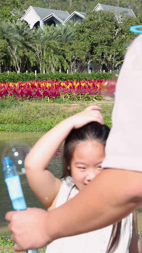 Happy Children Playing With Soap Bubbles Near Lake In Flower Garden Stock Footage 342093009