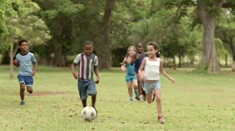 Happy children playing soccer with ball in park Stock Footage
