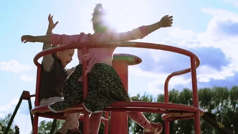 Happy children spinning on the carousel with their hands up. Slow Motion Stock Footage 78486420