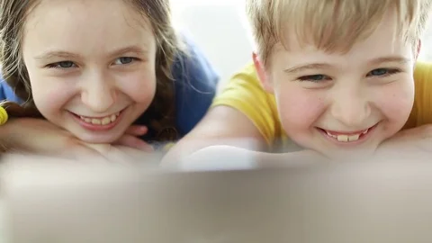 Happy children using smartphone together browsing online. Boy and girl at home l Stock Footage 78071313
