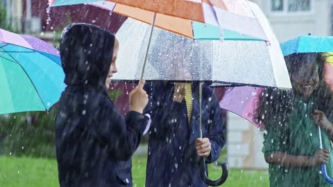 Happy Children Walking in Heavy Rain Stock Footage