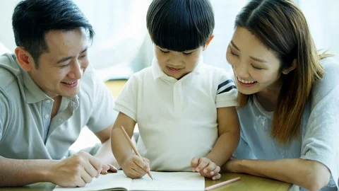 Happy Chinese Asian boy drawing pictures with parents Stock Footage