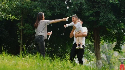 Happy Chinese family playing outdoor in the park Stock Footage
